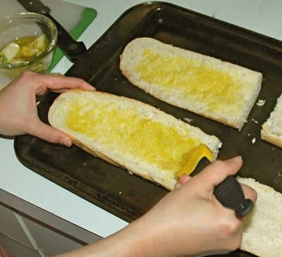 brushing garlic bread